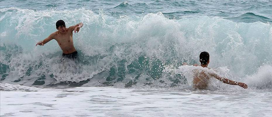 Antalya’da yabancı turistler dalgalara rağmen denize girdi