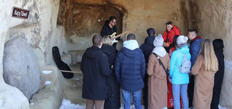Kapadokya'da tura katılan turistler 'gitarlı rehber'in nağmeleriyle eğleniyor