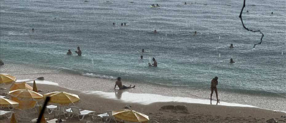 Antalya’da yağmura aldırış etmeyen turistlerin deniz keyfi